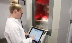 Opératrice devant une enceinte climatique